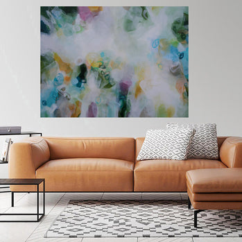 Modern living room with a brown leather sofa, abstract painting, and side table.