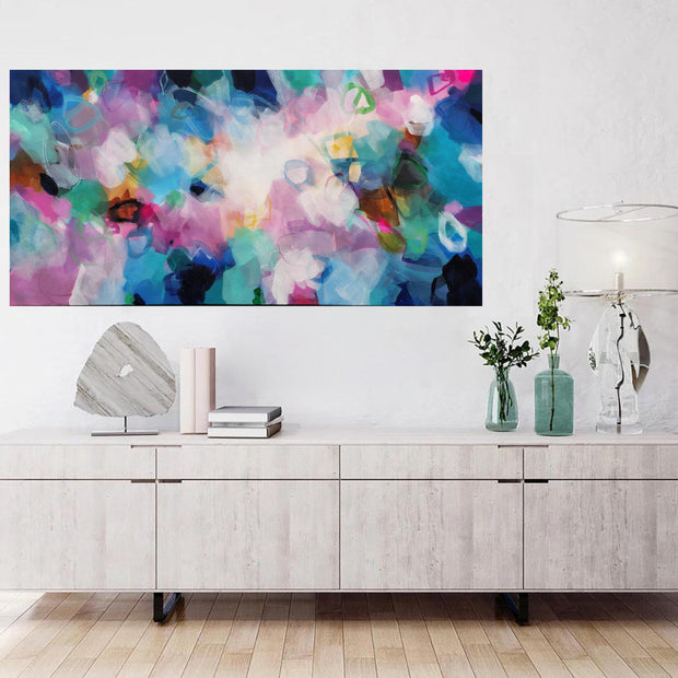 Modern living room with a colorful abstract painting above a wooden cabinet.