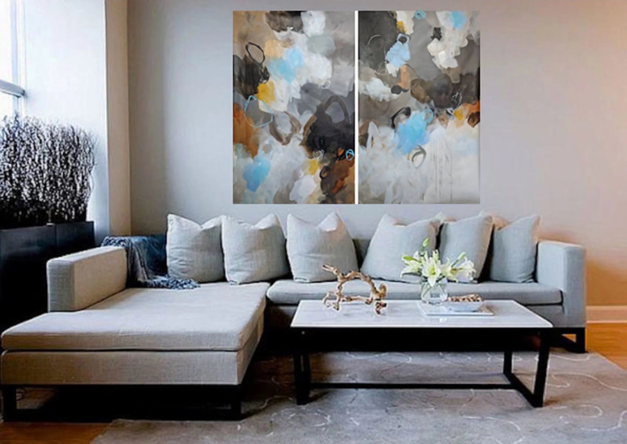 Living room with a sectional sofa, coffee table, and abstract wall art.