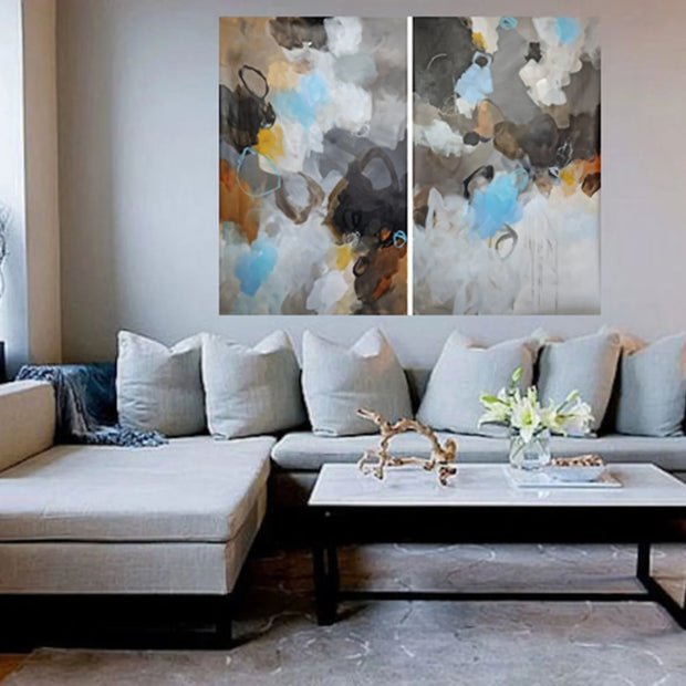 Living room with a sectional sofa, coffee table, and abstract wall art.