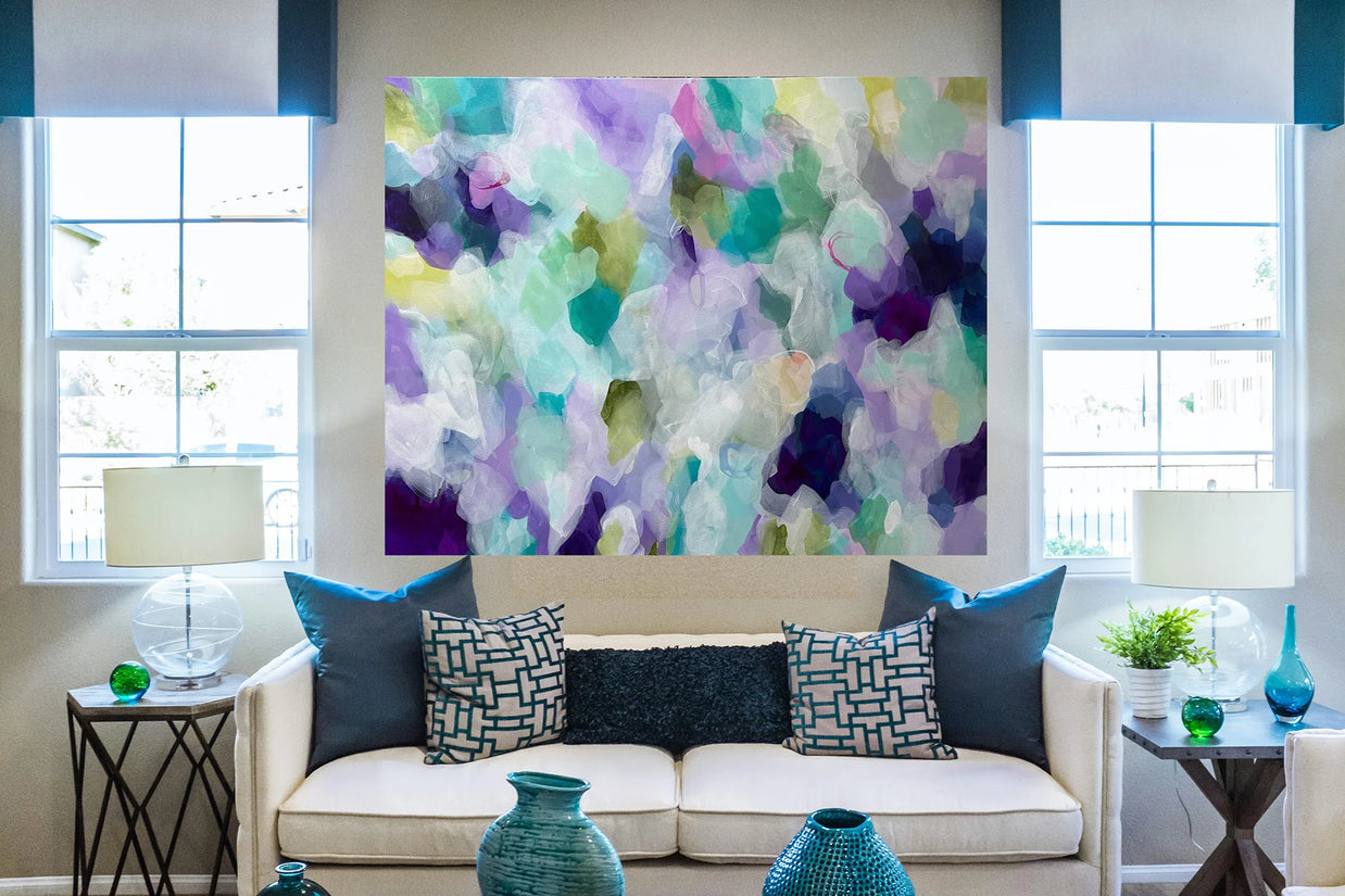 Living room with a colorful abstract painting above a beige sofa with blue and patterned cushions.