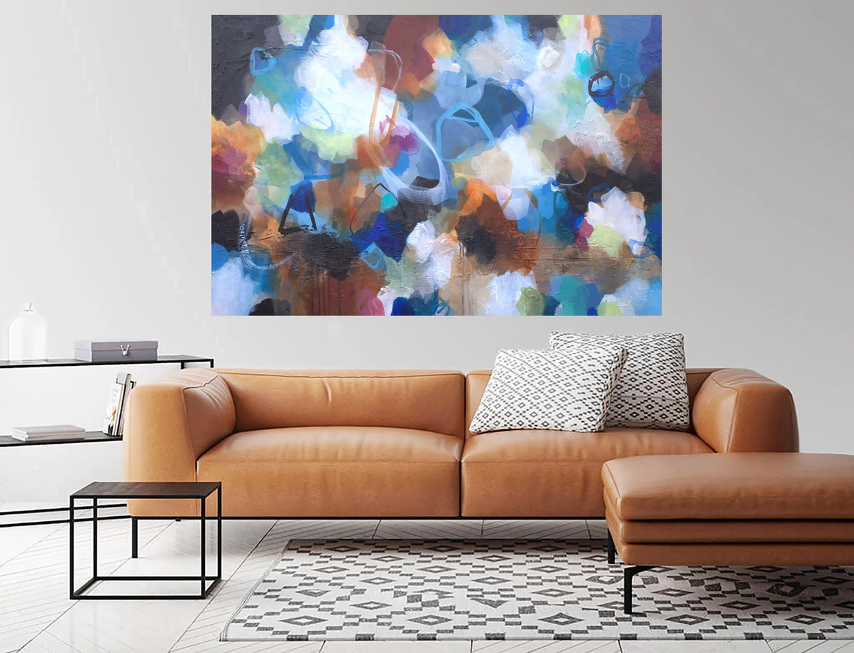 Modern living room with a brown leather sofa, abstract painting, and side table.