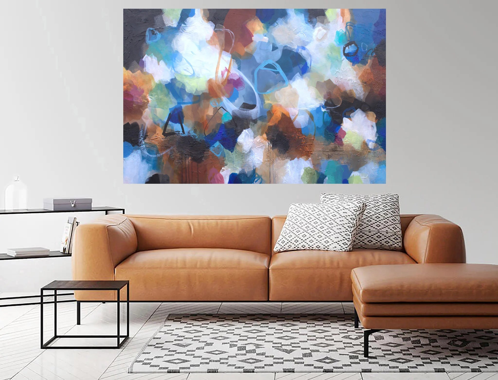 Modern living room with a brown leather sofa, abstract painting, and side table.
