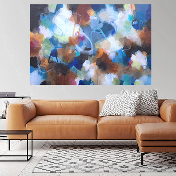 Modern living room with a brown leather sofa, abstract painting, and side table.