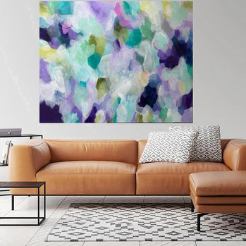 Modern living room with a brown leather sofa, abstract painting, and side table.