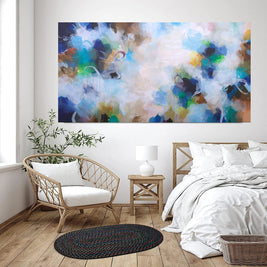 Modern bedroom with abstract artwork on the wall, wicker chair, and wooden nightstand.