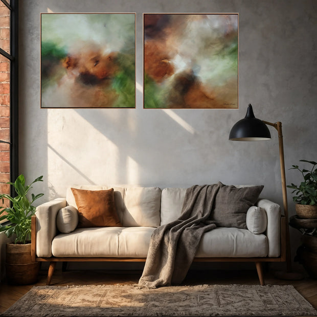 Two abstract canvas prints with earthy brown, green, and cream tones hanging side-by-side on a textured gray wall above a modern beige sofa in a styled living room.