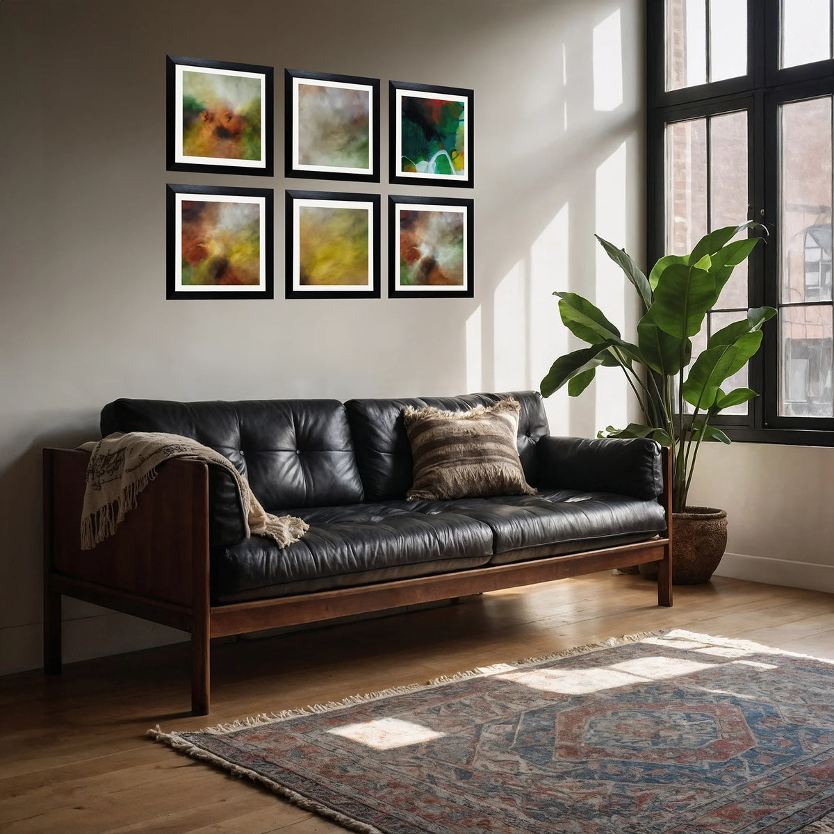 Six framed abstract art prints with black frames are arranged in two rows of three on a light beige wall above a mid-century modern black leather sofa in a sunlit living room.