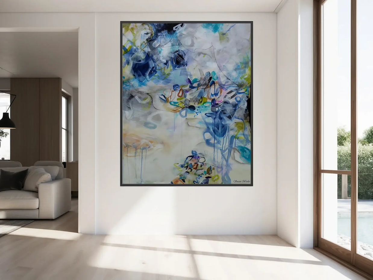 Abstract painting in a modern living room with large windows.