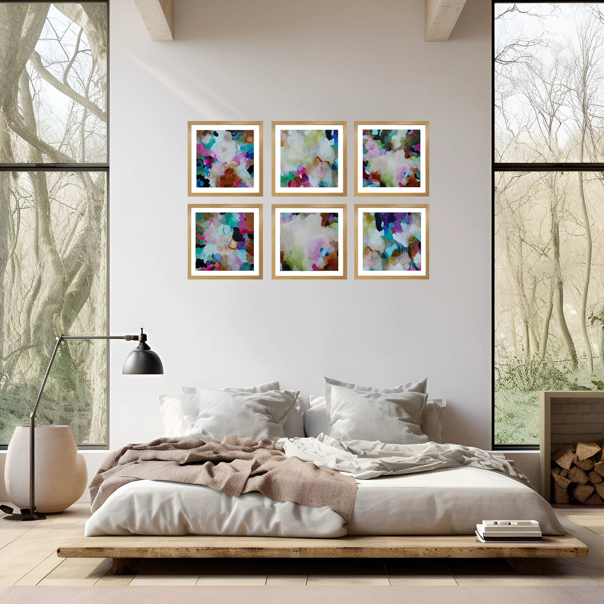 Six framed abstract watercolor art prints in a 2x3 grid are displayed on a light beige wall above a modern low-profile platform bed in a bright, contemporary bedroom.