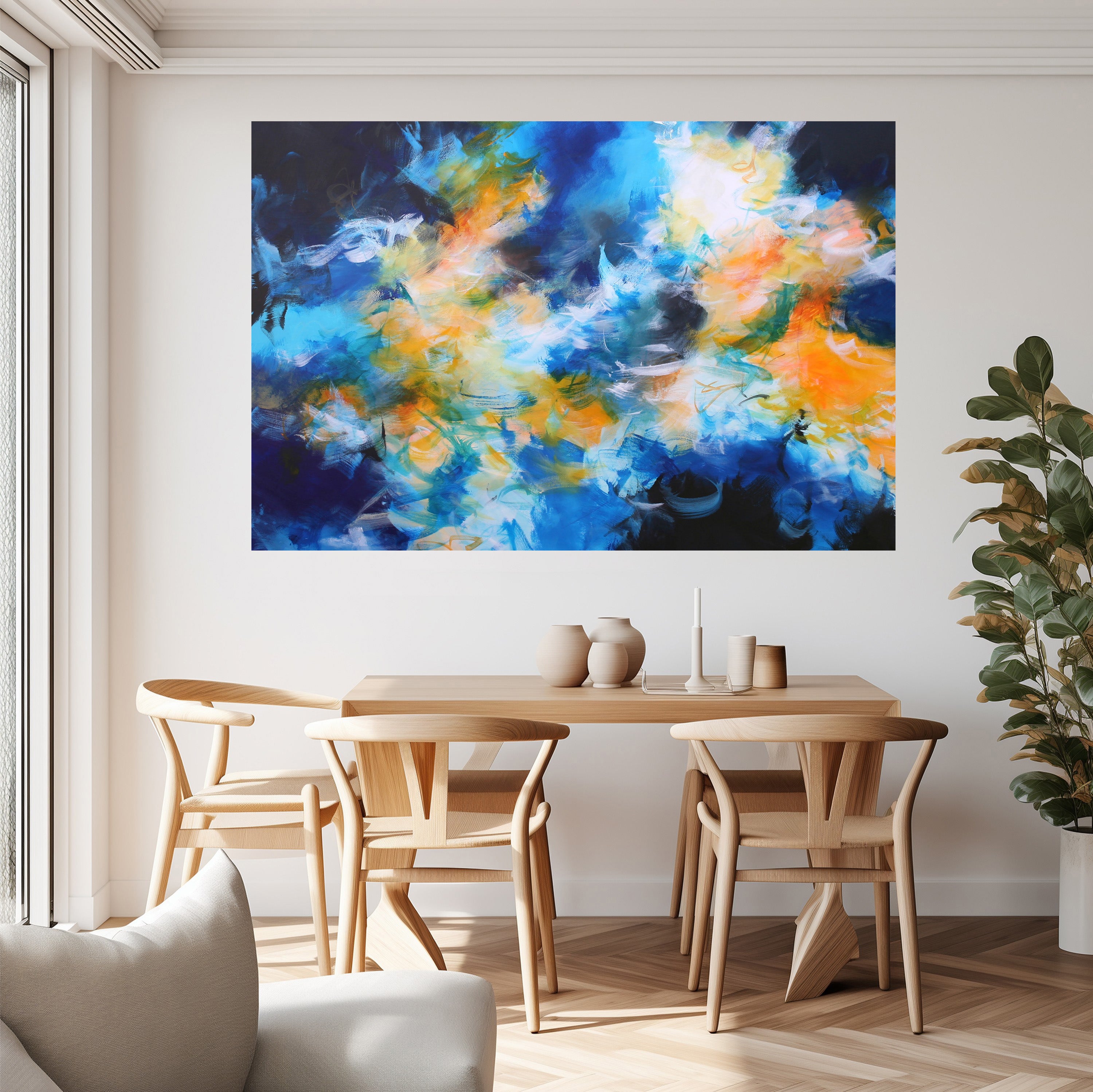 Dining room with a wooden table and chairs, colorful abstract painting on the wall, and a plant.