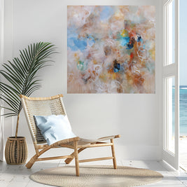 Modern interior with a wicker chair, abstract painting, and view of the ocean.