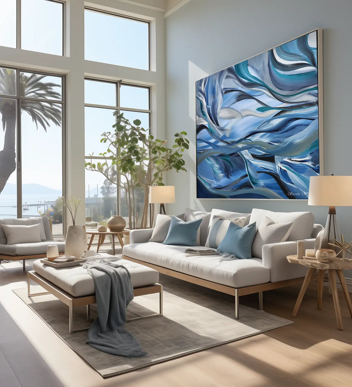 A large framed abstract canvas print with swirling blue, white, and teal waves hangs on a light gray wall above a modern white sofa in a bright, contemporary living room.