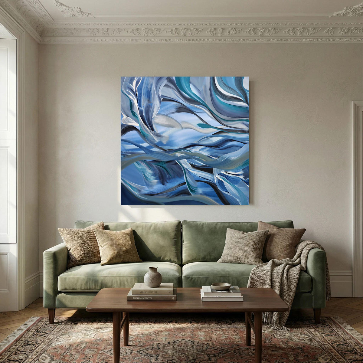 An abstract canvas painting with swirling blue, navy, and white patterns hangs on a beige wall above a green sofa in a styled living room.